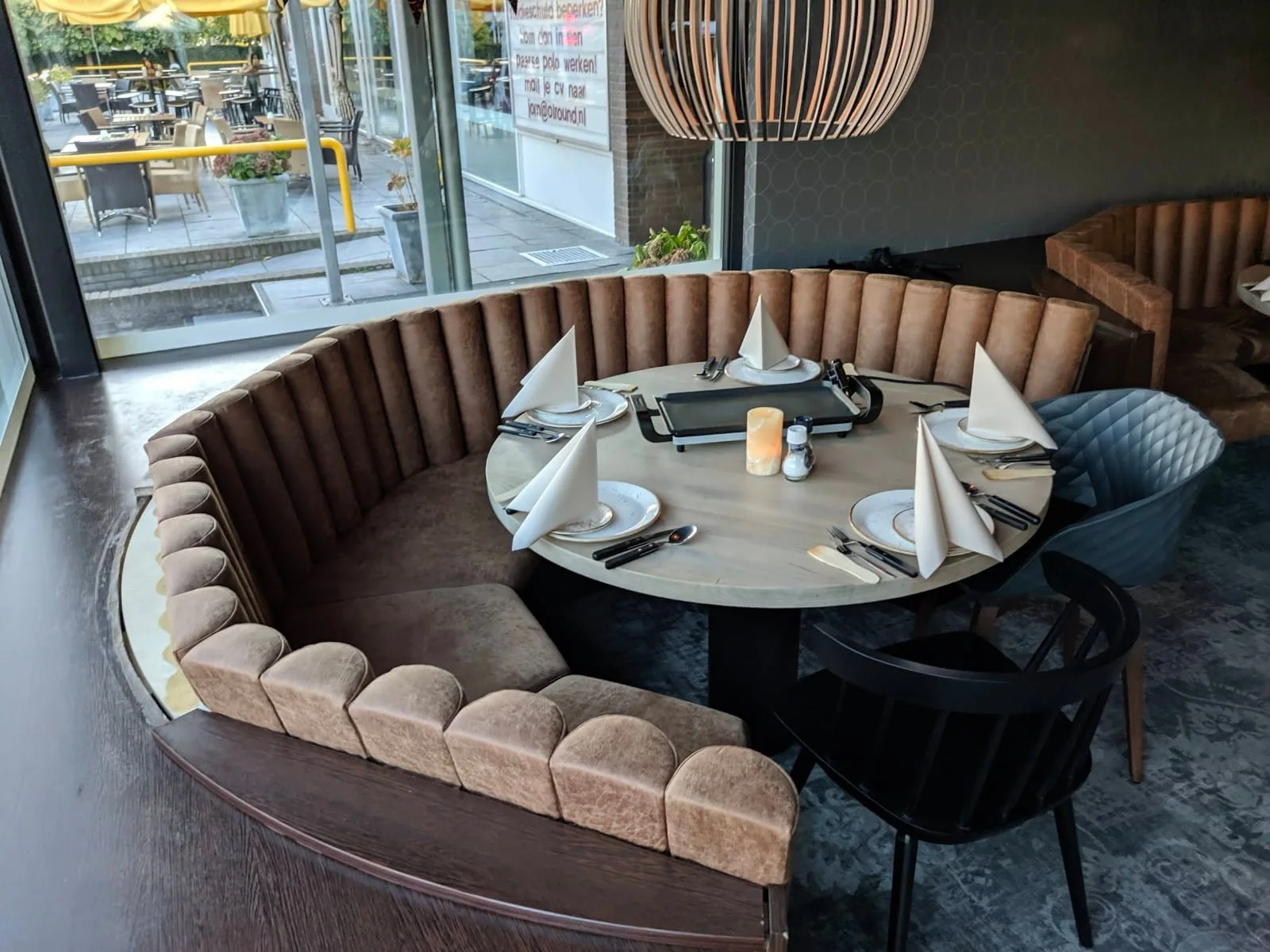 Ronde gestoffeerde zitbank rond een restauranttafel